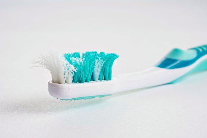 close up on old worn toothbrush with curled bristles