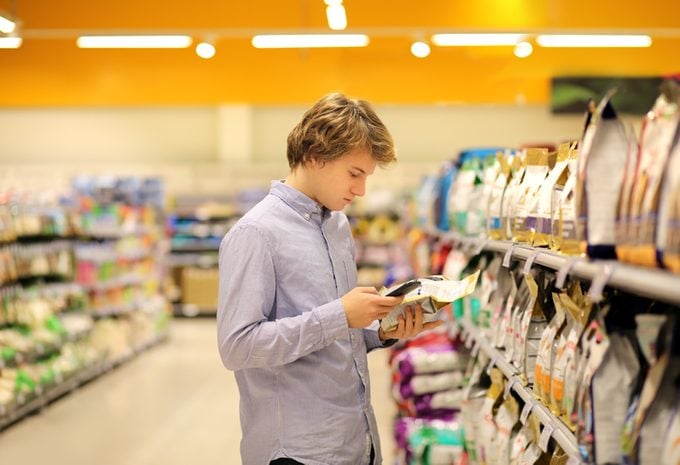 Man reads over product in Supermarket aisle