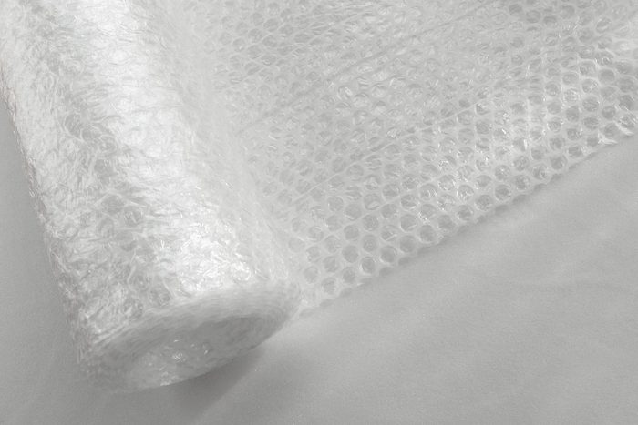 Transparent bubble wrap roll for packaging fragile items on white background