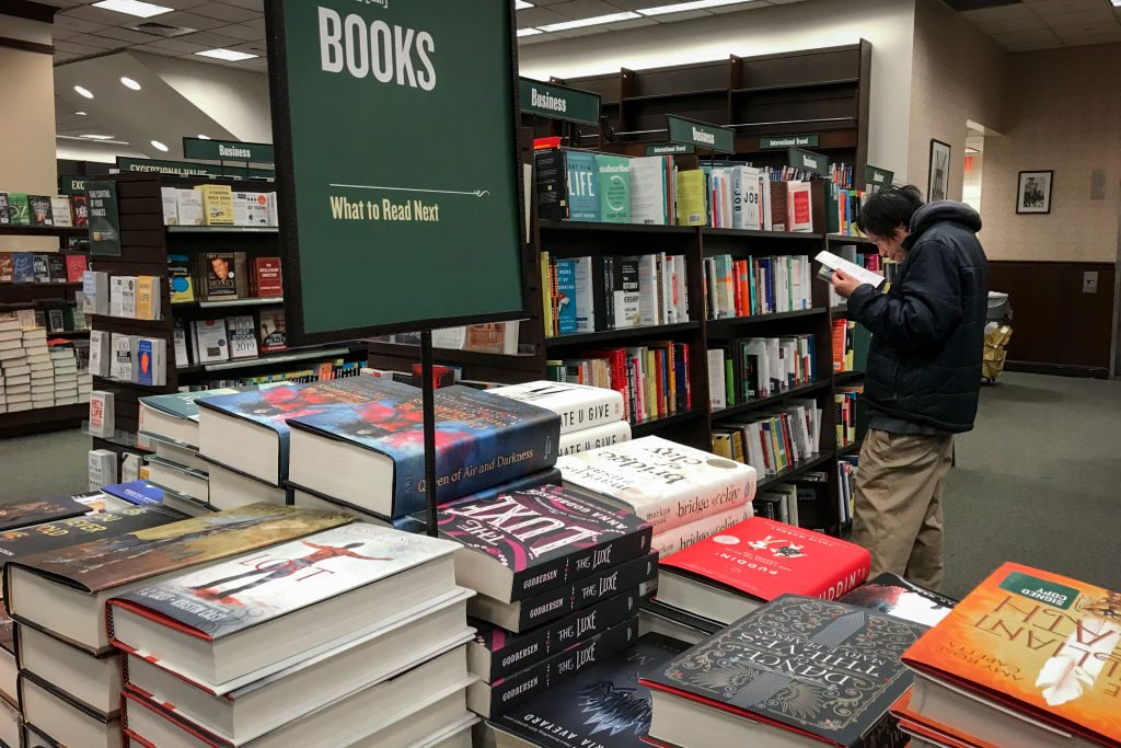 A shopper looks through a book at a Barnes & Noble bookstore
