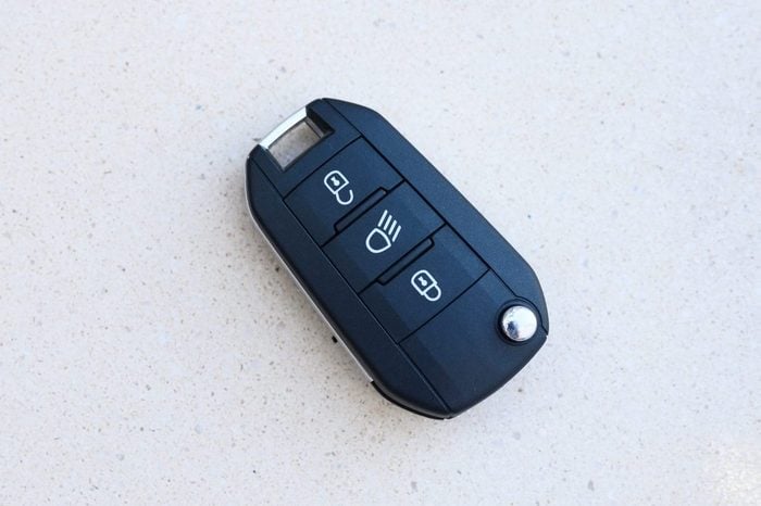 car key with remote control on blank textured red background