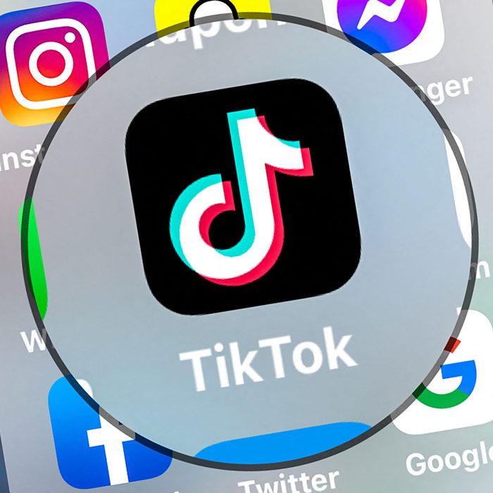 TikTok App Logo displayed on a smartphone screen under a magnifying circle
