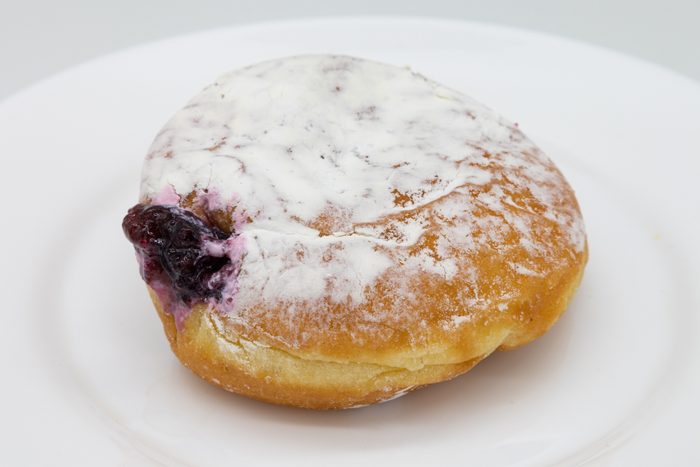 Delicious Powdered Jelly Donut on a White Plate with a White Background