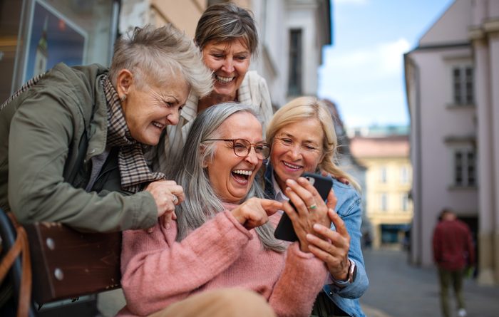 Group of happy senior women on a walk in city, taking selfie.