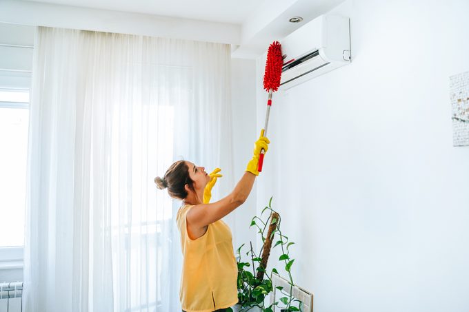 Woman Cleaning Air Conditioning System stock photo