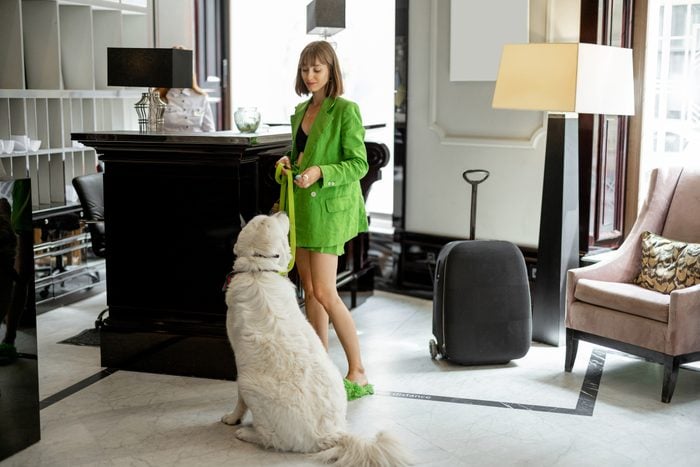 Business woman with her dog at hotel reception