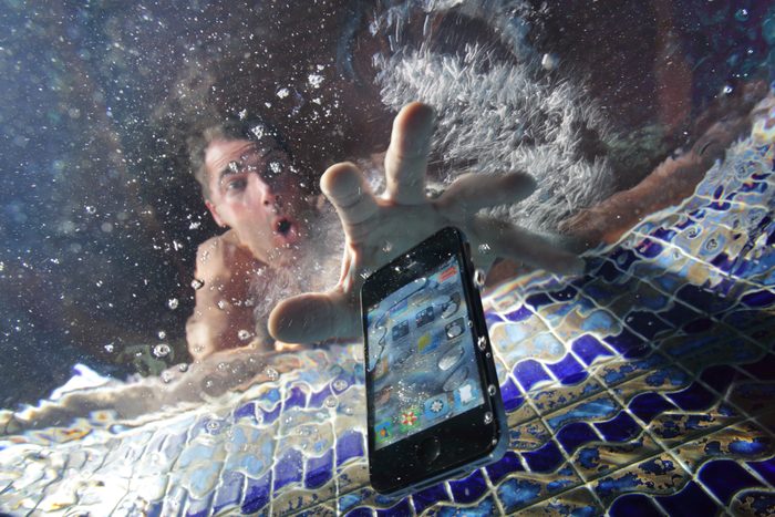 Smart phone being dropped into swimming pool