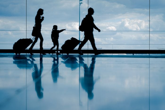 silhouette of Family at the airport walking with luggage