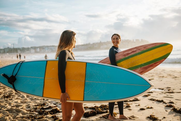 Two female friends with surfboards