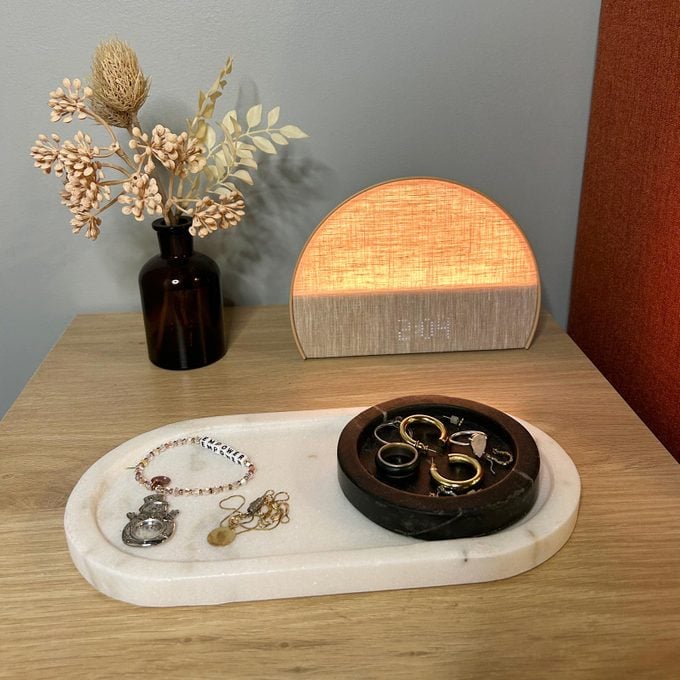 Sunrise Clock glowing on a bedside table