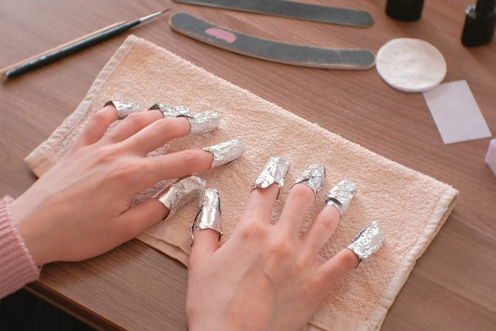 two hands with foil over all nails to remove gel polish