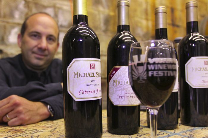 Michael Shaps next to bottles of wine from his namesake label at Virginia Wineworks Festival