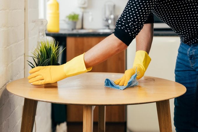 hand wearing yellow rubber gloves Wiping the Table