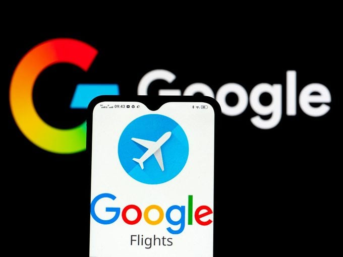 Google Flights Logo Displayed on a Smartphone in Front of Google Logo