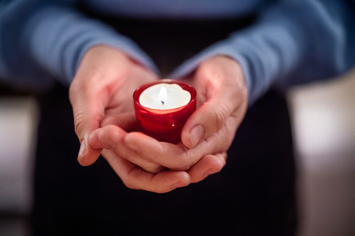 Close-up of woman holding a votive candle