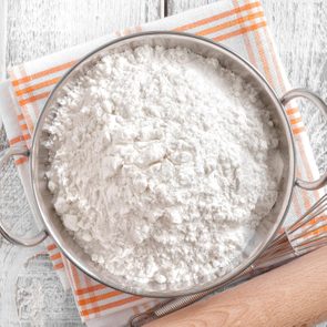 Bowl of flour in a napkin with a roller pin