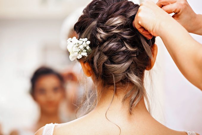 Unknown person adjusts brides hair before the wedding ceremony