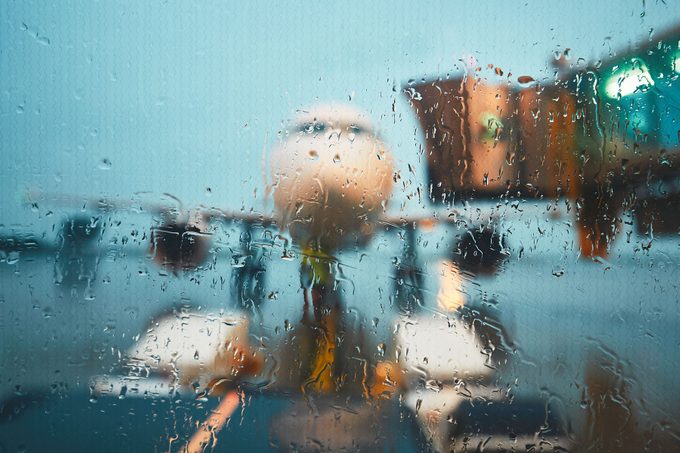 A plane sits at the airport gate as the rain delays air traffic