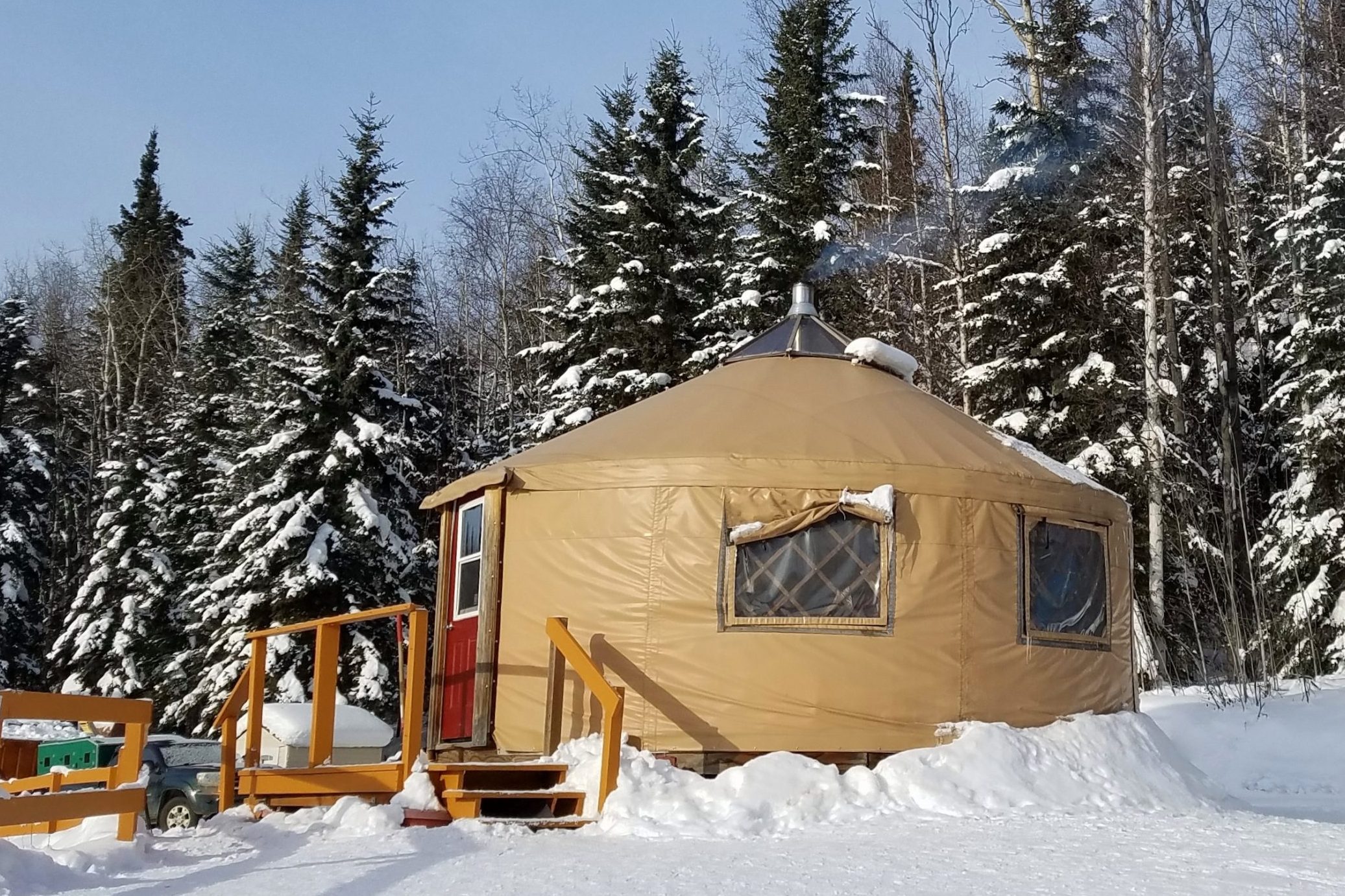 Small Circular Housing, a Yurt, in a Snowy Evergreen Setting