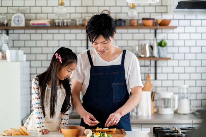Young father and daughter cooking together at home