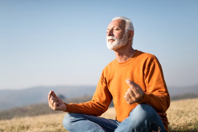 Senior man meditating in nature.