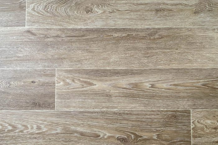 The surface texture of rubber artificial brown linoleum with a design for wood planks with knots. The background