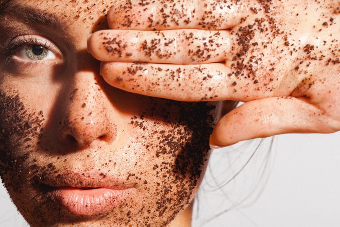 Beauty portrait of a young woman with ground coffee over her clean healthy skin