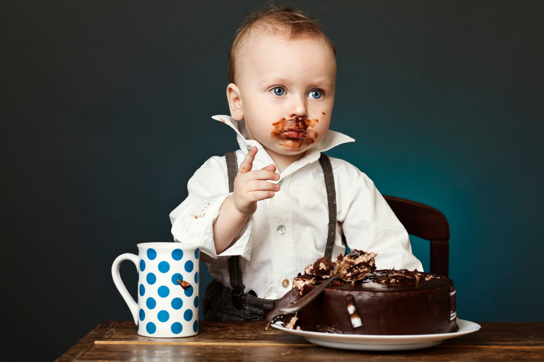 A child covered in chocolate cake on his face