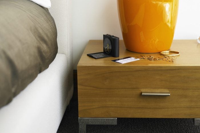 Nightstand with alarm clock, hotel keycard and jewelry