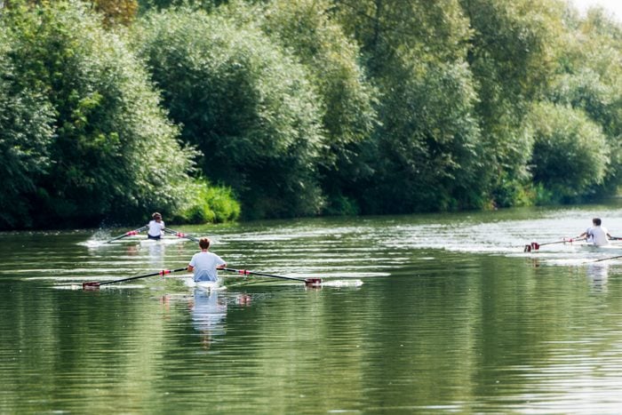Young male students in Oxford rowing on the River Thames