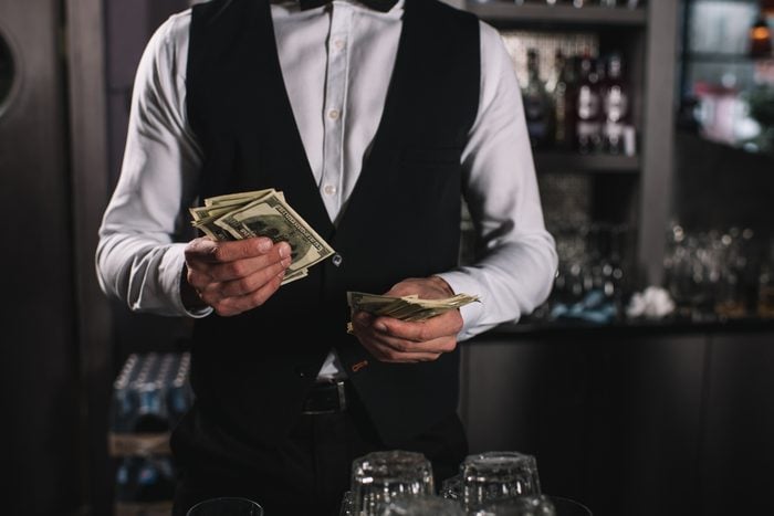 cropped image of bartender counting tips