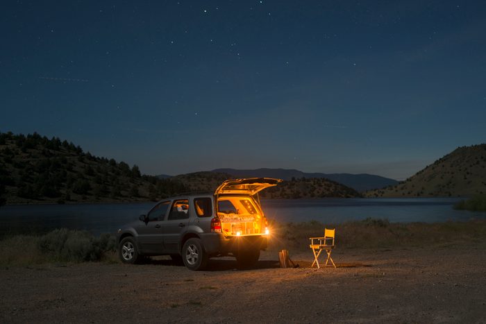 Sports utility vehicle parked on shore by Lake Shastina against sky during night