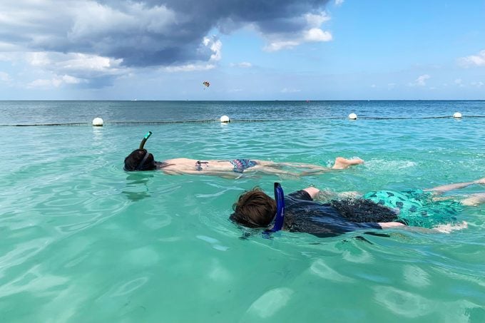 two people snorkeling in turquoise blue waters
