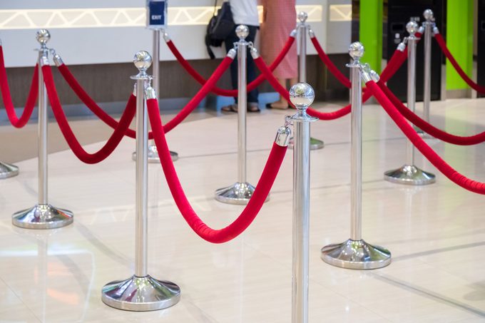 Red Velvet Rope Separates Standing Line Queues on a white marble floor