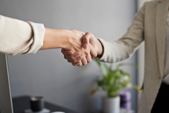 Female entrepreneurs shaking hands at workplace