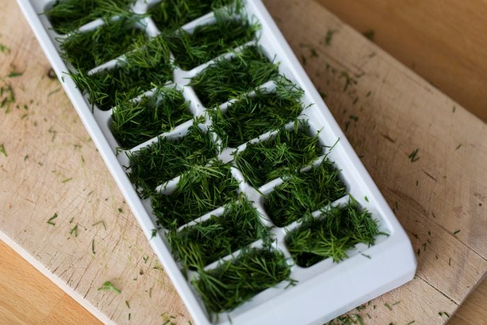 Fresh green chopped herbs in ice cube tray
