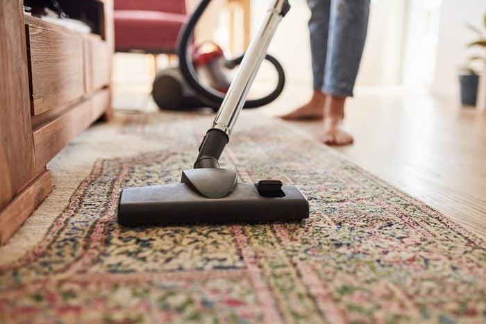 person vacuuming a patterned carpet