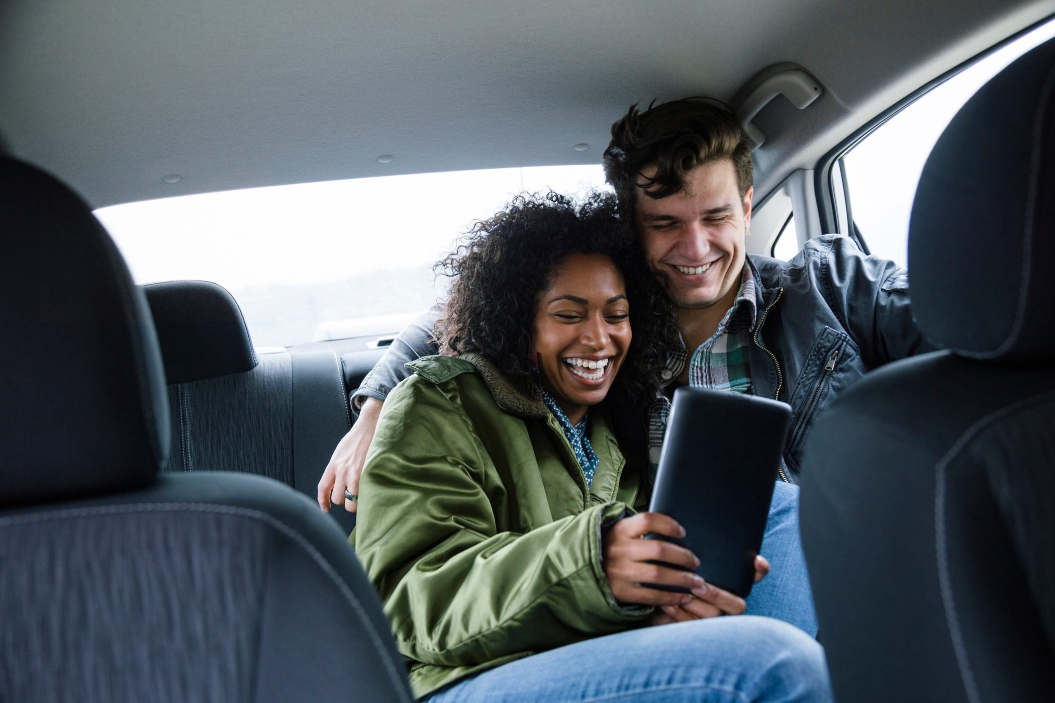 Young couple taking selfie in car during road trip