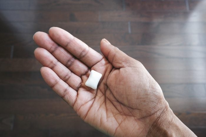 Woman Holds Piece of Sugar-Free Chewing Gum