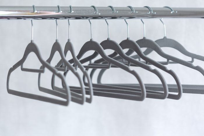 Modern grey empty hangers on neutral wall background