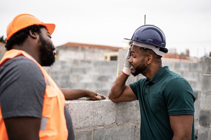 Worried coworkers talking in a construction site