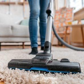 Young Woman Vacuuming Her Apartment