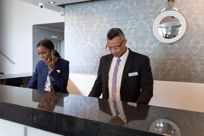 Manager and receptionist working in a busy hotel