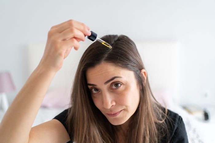 Portrait Of Applying Hair Serum To Her Hair