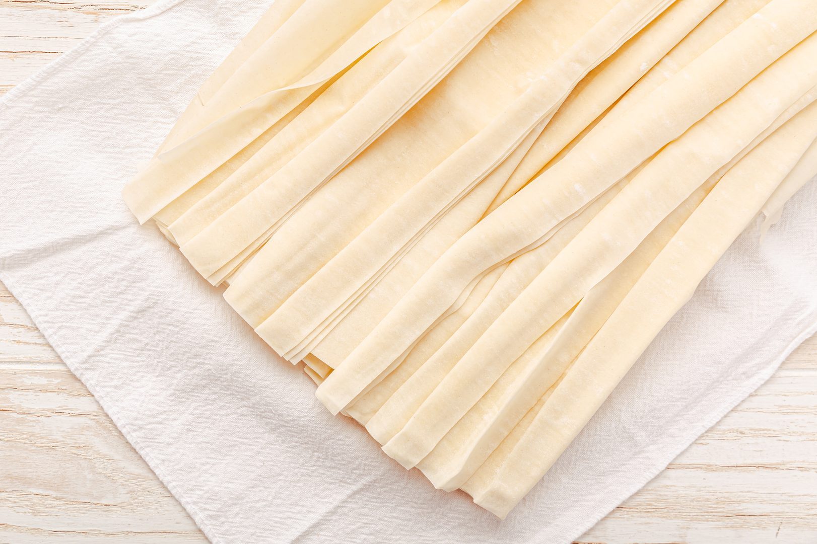 Raw phyllo pastry, thin filo dough for baking, for pie and cakes on wooden kitchen table