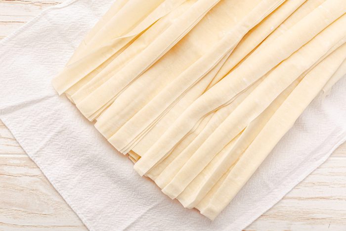 Raw phyllo pastry, thin filo dough for baking, for pie and cakes on wooden kitchen table