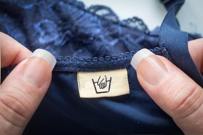 Woman pov holding lingerie with an handwash label
