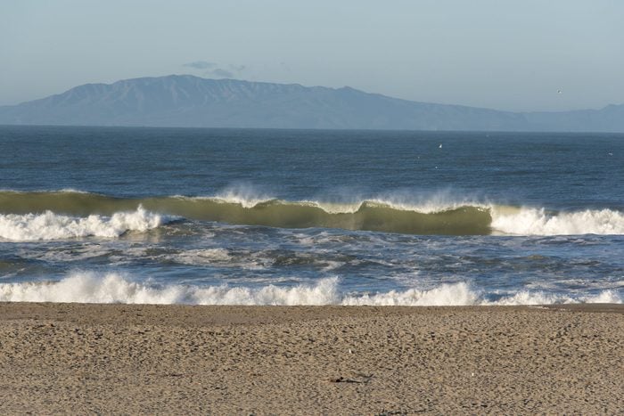 Offshore wind blowing spray back from waves with Channel Islands on horizon, Oxnard, California, USA