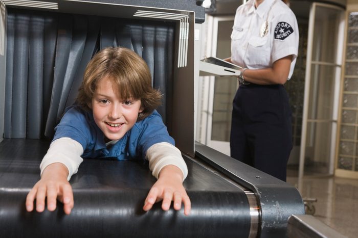 Playful pre-teen boy going through airport security checkpoint