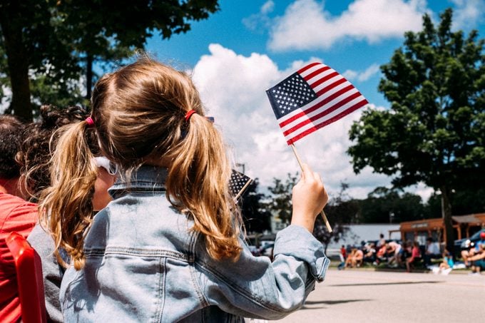 Rear view of girl holding American Flag during Independence Day